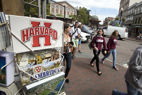 Students walk past a store selling Harvard merchandise.