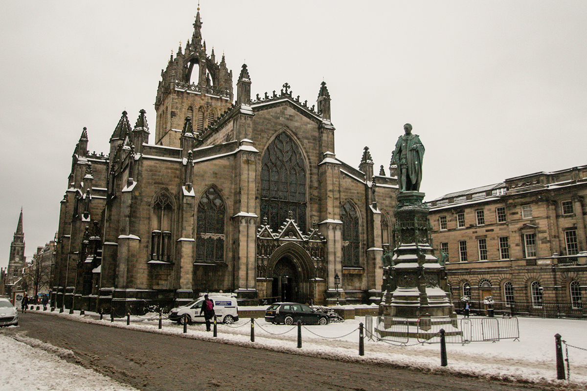 St. Giles Cathedral, a gothic structure with crown steeple just peeking into view from street. 