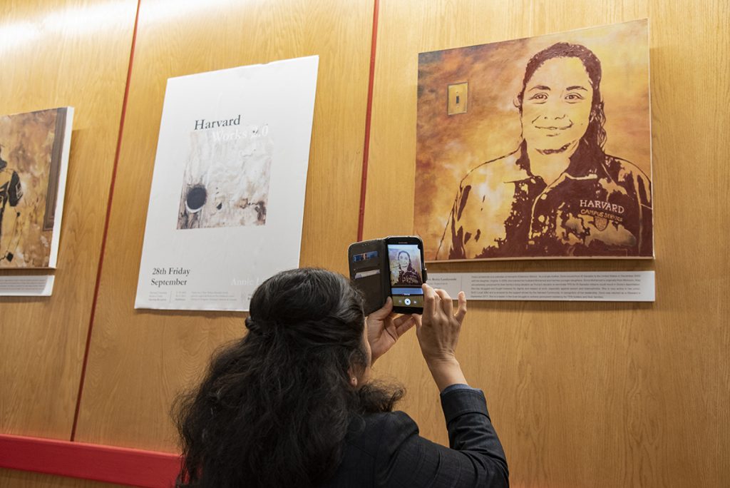 Doris Landaverde takes a photo of her portrait during the exhibition's opening reception. 