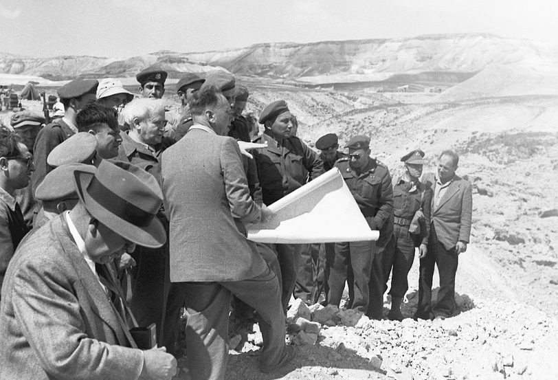 Architects and soldiers observing a map and terrain