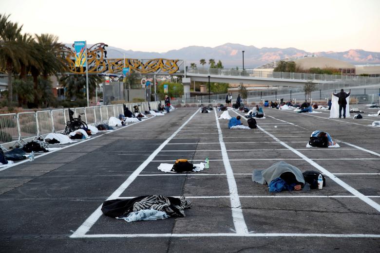 Homeless people sleep in a temporary parking lot shelter at Cashman Center