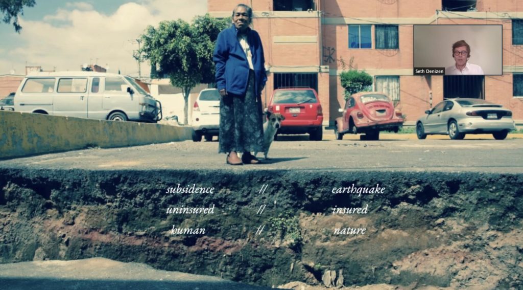 Screenshot from a presentation on Zoom by Seth Denizen. An older woman stands on a street that has cracked and moved as a result of an earthquake. Seth Denizen appears in a small window in the top right corner.