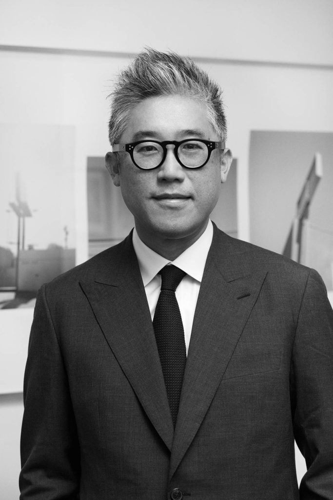 Black-and-white headshot of Mark Lee, who wears glasses and a suit and tie.