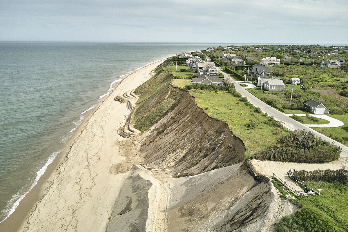 Eroded coastal shore with houses above small cliff