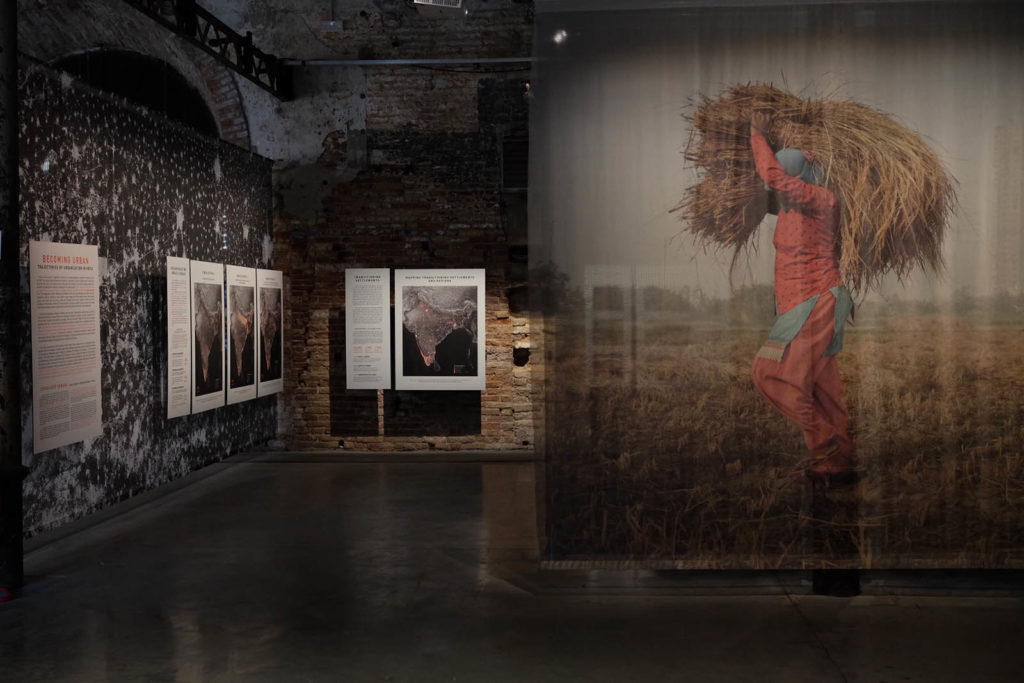 Entrance to an installation featuring a large photograph of a woman carrying straw.