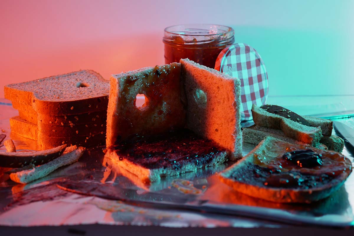 stacks of sliced bread with jelly illuminated in green and pink light