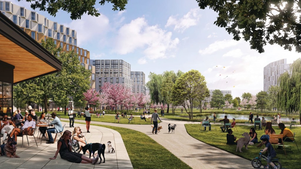 Rendering of the Suffolk Downs Master Plan show a vibrant landscape design populated by people and pets walking on paths. Groups lounge in the shade under trees and play by the water. There are kits in the sky. The scene is joyful and bright.