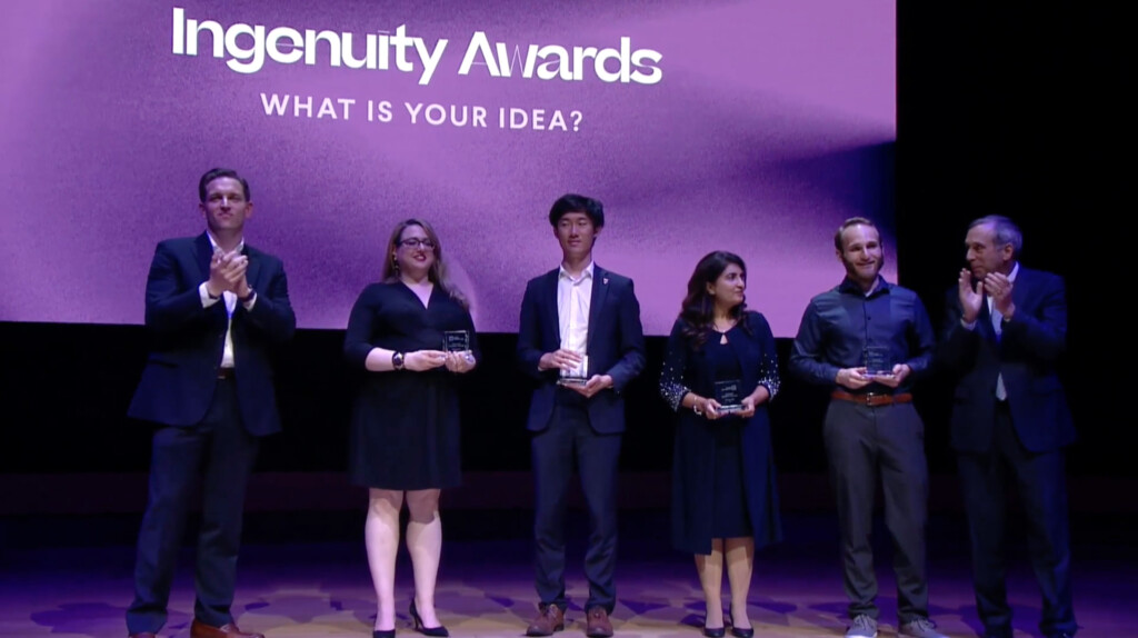 Award recipients stand on stage holding awards at the 2022 President’s Innovation Challenge ceremony.
