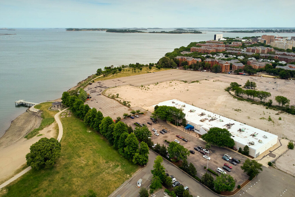 Aerial photo of a parking lot and the bay in the upper left side.