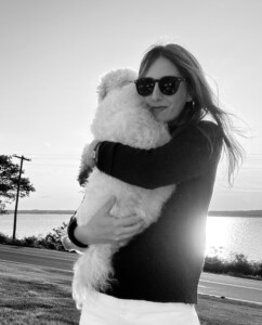 Annie Simpson holding a white dog. 